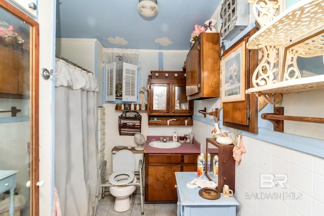 bathroom with curtained shower, tile patterned floors, vanity, and toilet