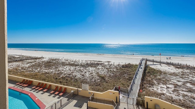 view of water feature featuring fence and a view of the beach