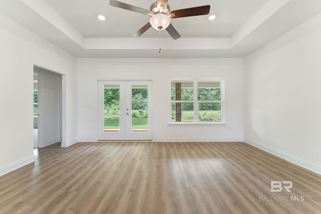 1819 Mary Jane Dr, Bay Minette, AL 36507 - empty room with a tray ceiling, a healthy amount of sunlight, and wood finished floors
