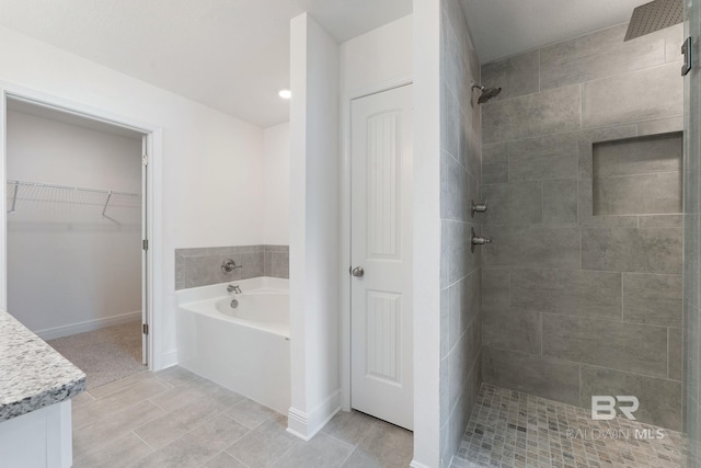 1819 Mary Jane Dr, Bay Minette, AL 36507 - bathroom with a garden tub, tile patterned floors, baseboards, a spacious closet, and tiled shower