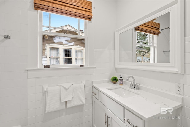 bathroom with vanity and tile walls