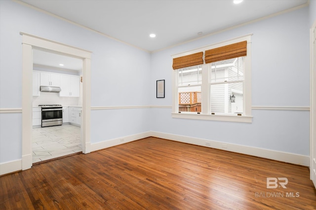 empty room featuring hardwood / wood-style floors and crown molding