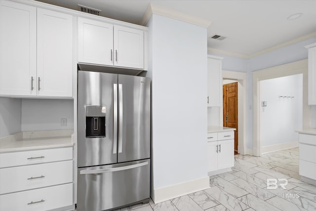 kitchen featuring white cabinets, crown molding, and stainless steel fridge