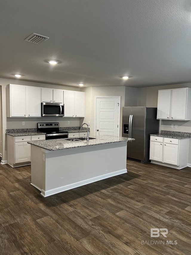 kitchen featuring light stone countertops, visible vents, dark wood-style flooring, a sink, and stainless steel appliances