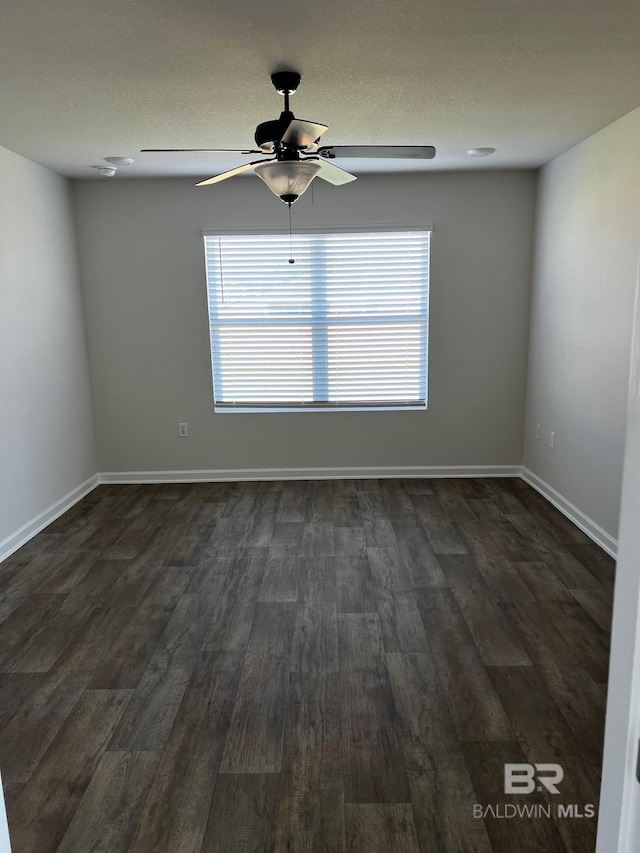 unfurnished room with ceiling fan, baseboards, and dark wood-style flooring