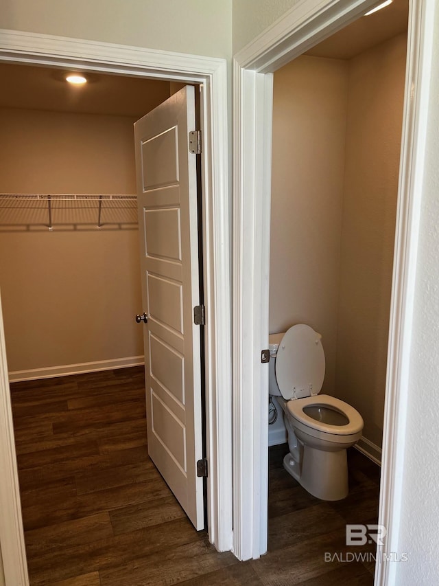 bathroom with toilet, wood finished floors, and baseboards