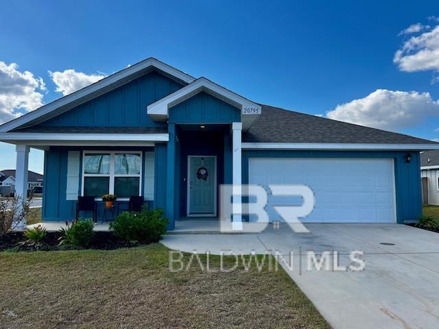 view of front of home featuring a front lawn, driveway, board and batten siding, covered porch, and a garage