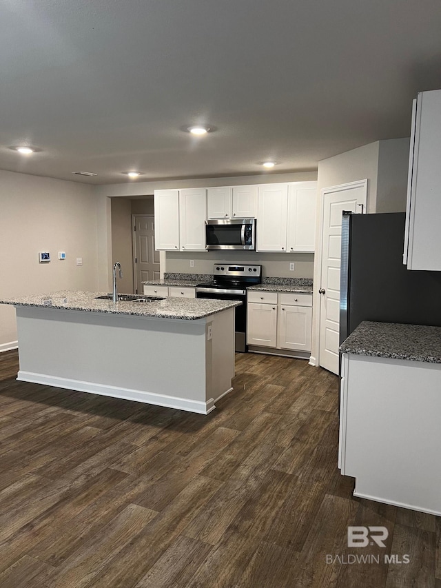 kitchen featuring a sink, stainless steel appliances, dark wood-type flooring, and white cabinets