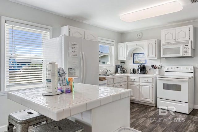 467 W Bernard Ct, Gulf Shores, AL 36542 - kitchen with white appliances, tile counters, white cabinetry, and dark wood-style flooring