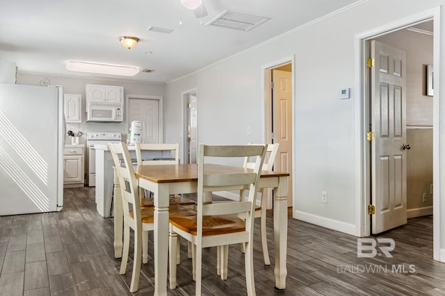 467 W Bernard Ct, Gulf Shores, AL 36542 - dining room featuring dark wood-style flooring, ornamental molding, and baseboards