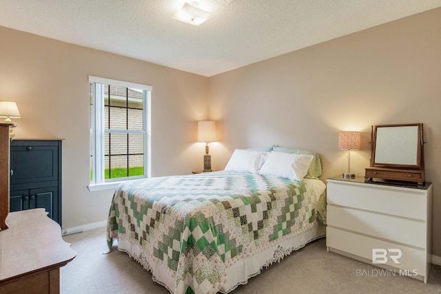 bedroom with a textured ceiling and light colored carpet