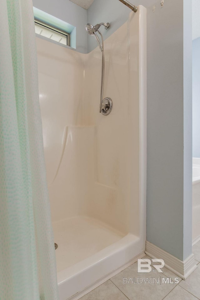 bathroom with a shower with curtain and tile patterned floors