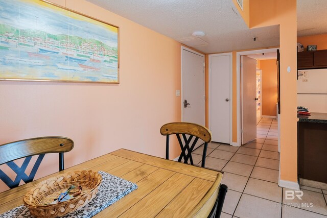 tiled dining area featuring a textured ceiling