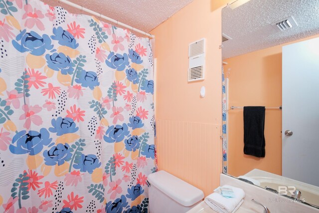 bathroom featuring toilet and a textured ceiling