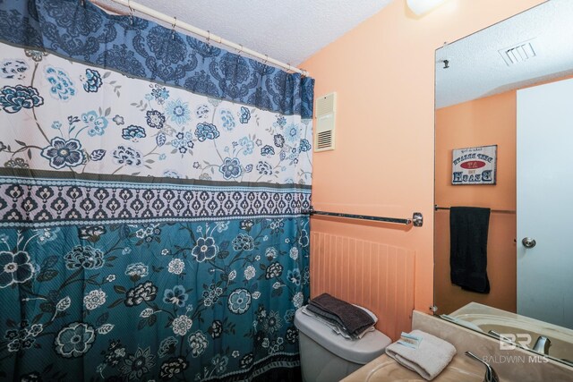 bathroom with toilet and a textured ceiling