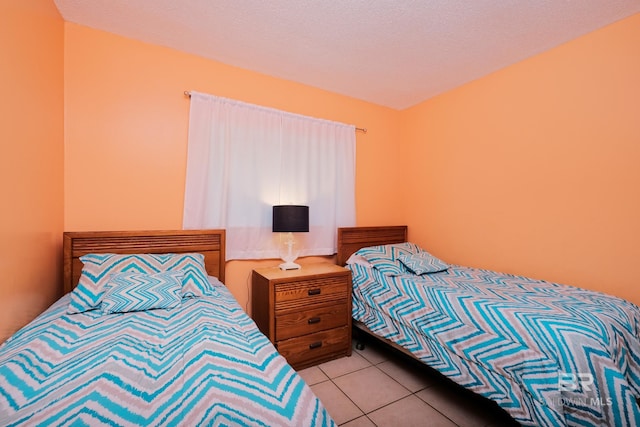 bedroom with a textured ceiling and light tile patterned flooring