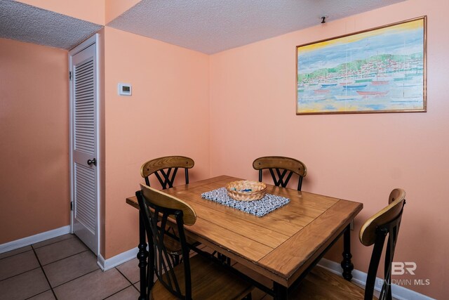 dining room featuring a textured ceiling and tile patterned flooring