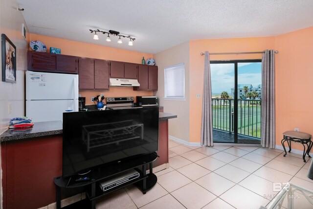 kitchen featuring light tile patterned flooring, stainless steel range with electric stovetop, a textured ceiling, track lighting, and white refrigerator