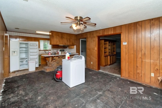 3909 Blue Gill Cir, Mobile, AL 36619 - kitchen with brown cabinets, washer / clothes dryer, wooden walls, a ceiling fan, and a textured ceiling