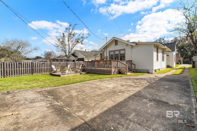 back of property featuring a patio, fence, a yard, concrete driveway, and a wooden deck