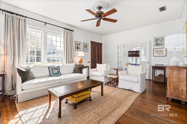 living area with visible vents, wood finished floors, and a ceiling fan