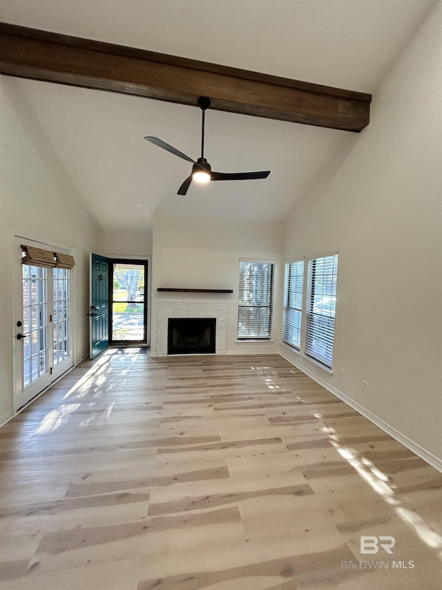 unfurnished living room with beam ceiling, baseboards, wood finished floors, ceiling fan, and high vaulted ceiling