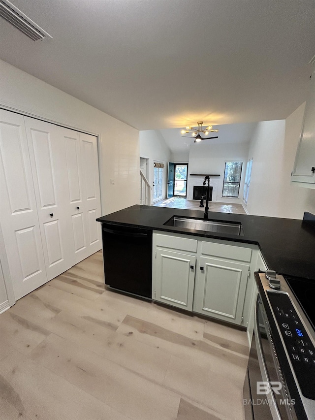 kitchen with a peninsula, a sink, visible vents, stove, and dishwasher