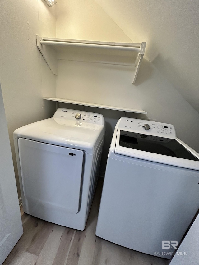 washroom featuring wood finished floors, washer and dryer, and laundry area