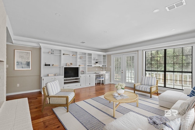 living room featuring a wealth of natural light, french doors, visible vents, and wood finished floors