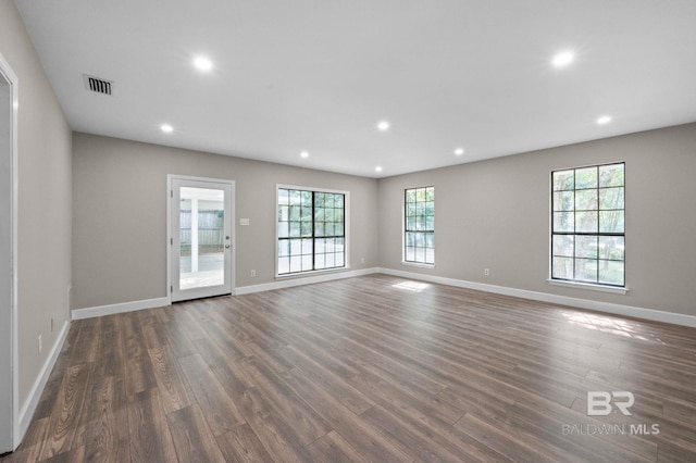 unfurnished living room with baseboards, wood finished floors, visible vents, and recessed lighting