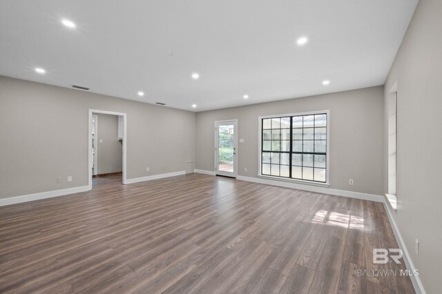 unfurnished room with baseboards, wood finished floors, visible vents, and recessed lighting