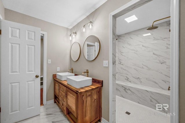 bathroom featuring marble finish floor, a sink, a marble finish shower, and double vanity