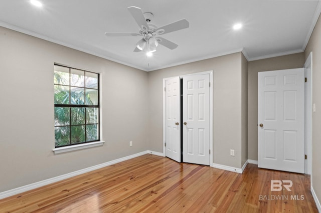 unfurnished bedroom featuring baseboards, a ceiling fan, light wood-style flooring, ornamental molding, and a closet