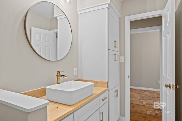 bathroom featuring vanity, baseboards, and wood finished floors