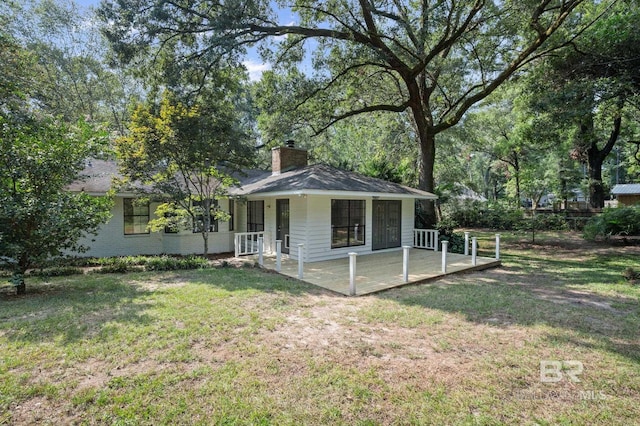 exterior space featuring a chimney, a front lawn, and brick siding