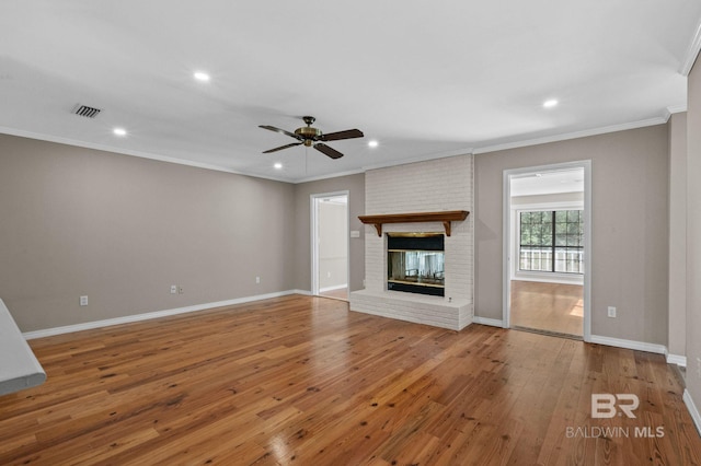 unfurnished living room with a brick fireplace, baseboards, and hardwood / wood-style floors