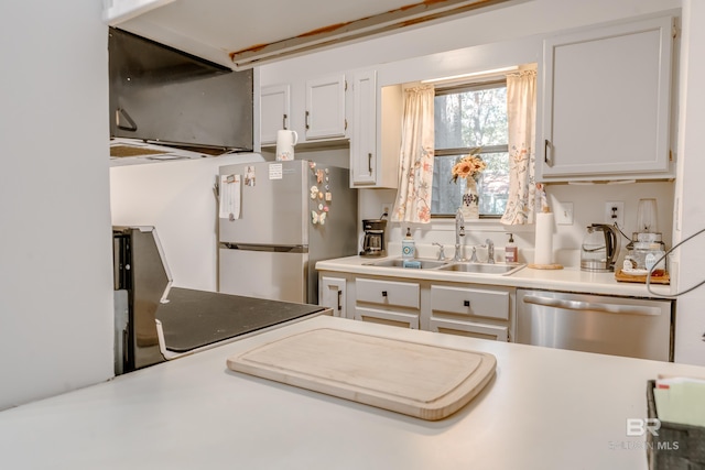 kitchen featuring stainless steel appliances, white cabinetry, and sink