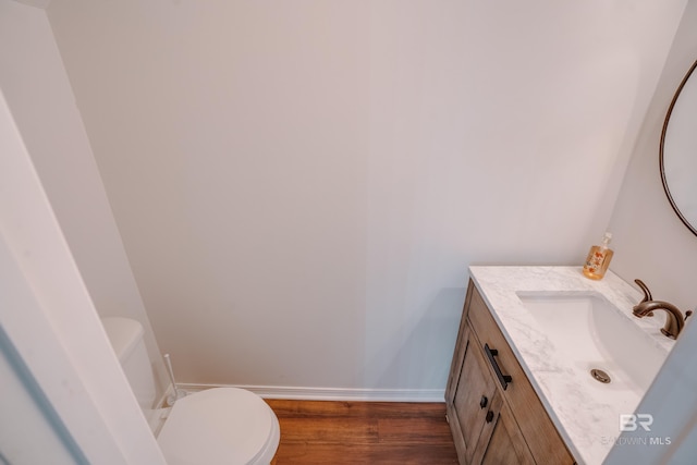 bathroom featuring hardwood / wood-style floors, vanity, and toilet