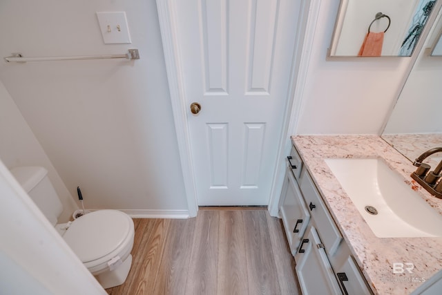 bathroom featuring hardwood / wood-style floors, vanity, and toilet