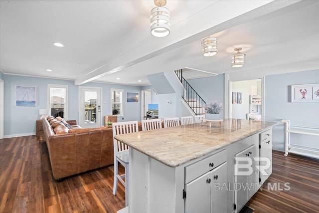 108 Ponchartrain Ct, Dauphin Island, AL 36528 - kitchen featuring dark wood finished floors, recessed lighting, a breakfast bar, open floor plan, and white cabinets