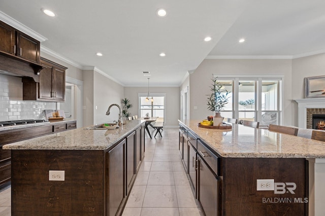 kitchen featuring a large island, sink, and light stone counters