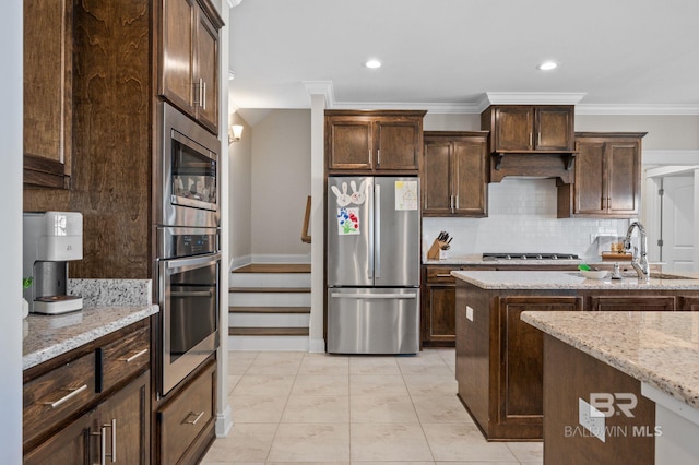 kitchen featuring crown molding, sink, appliances with stainless steel finishes, light stone counters, and dark brown cabinetry