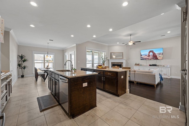 kitchen with ceiling fan, dishwasher, sink, an island with sink, and decorative light fixtures