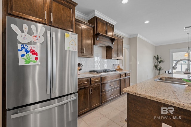 kitchen with sink, stainless steel appliances, backsplash, dark brown cabinets, and ornamental molding