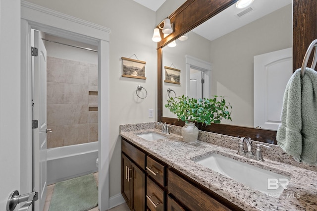 full bathroom featuring tile patterned flooring, vanity, tiled shower / bath combo, and toilet