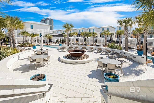 2457 Saltgrass Way Unit 8, Orange Beach, AL 36561 - view of property's community featuring a patio area, an outdoor fire pit, outdoor dining area, a swimming pool, and a residential view