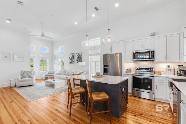 2457 Saltgrass Way Unit 8, Orange Beach, AL 36561 - kitchen featuring open floor plan, a center island, light wood-style floors, visible vents, and appliances with stainless steel finishes