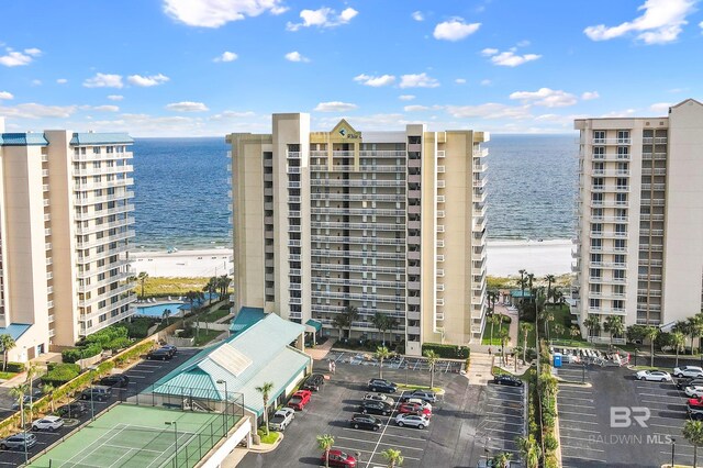 view of property with a water view and a beach view