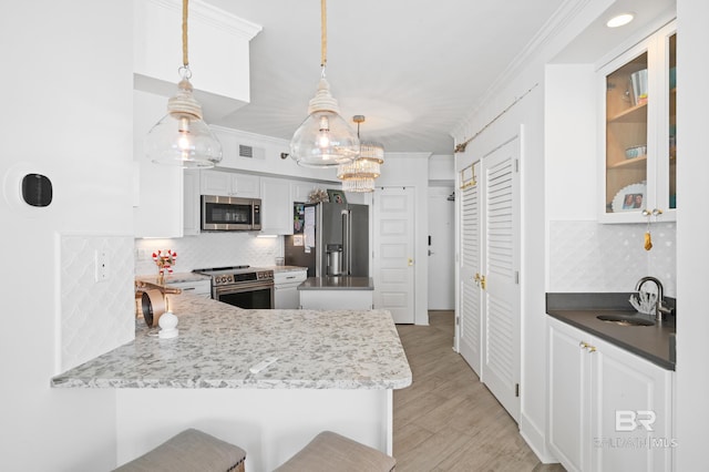 24900 Perdido Beach Blvd Unit 1001, Orange Beach, AL 36561 - kitchen with white cabinets, sink, hanging light fixtures, appliances with stainless steel finishes, and a breakfast bar area