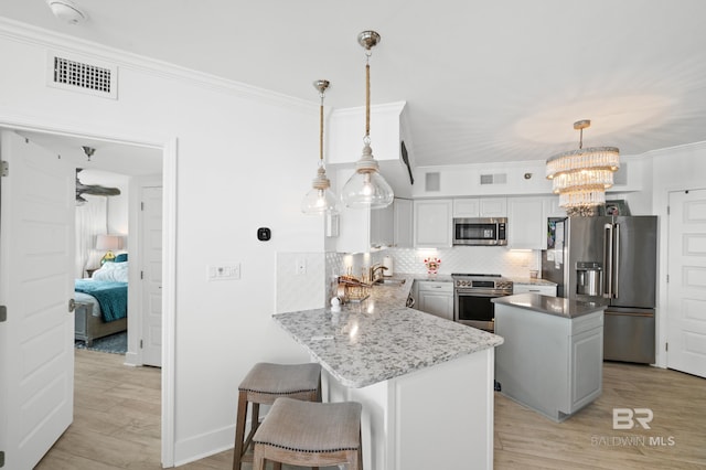 24900 Perdido Beach Blvd Unit 1001, Orange Beach, AL 36561 - kitchen with kitchen peninsula, white cabinets, pendant lighting, and appliances with stainless steel finishes